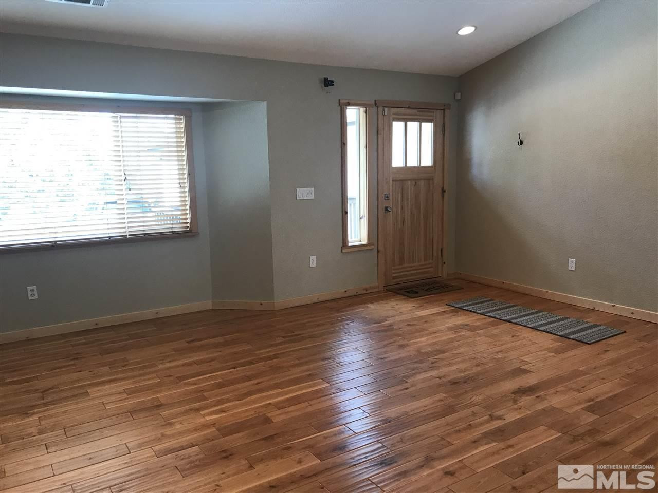 21715 Sazarac Road Reno, NV 89521 - Photo 5 of 25 an empty room with wooden floor and windows