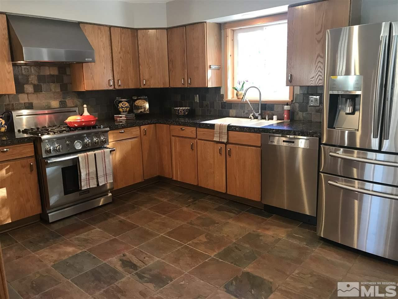 21715 Sazarac Road Reno, NV 89521 - Photo 8 of 25 a kitchen with stainless steel appliances granite countertop a stove a sink and a refrigerator