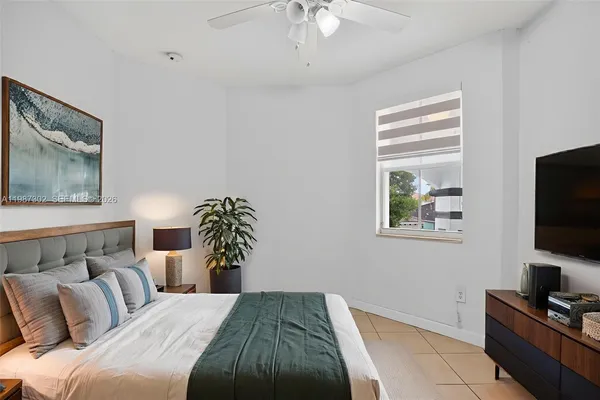 an empty room with white walls and ceiling fan