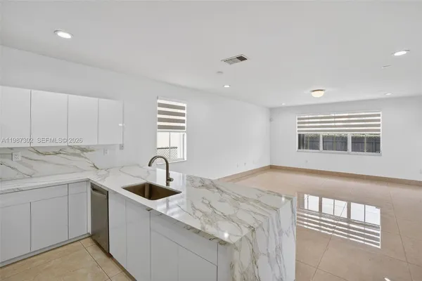 a kitchen with stainless steel appliances kitchen island granite countertop a sink stove and refrigerator