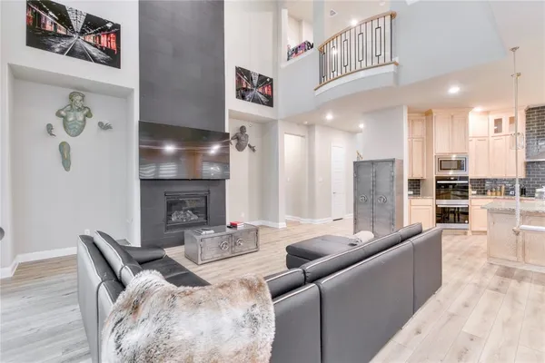 a kitchen with kitchen island granite countertop a stove a sink a refrigerator and white cabinets with wooden floor