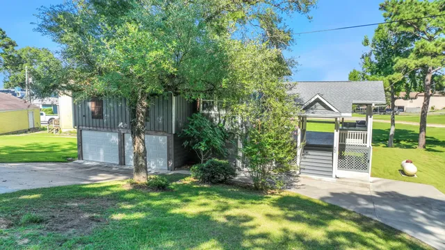 a view of a small yard in front of a house with large tree
