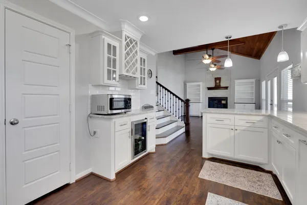 a kitchen with cabinets and wooden floor