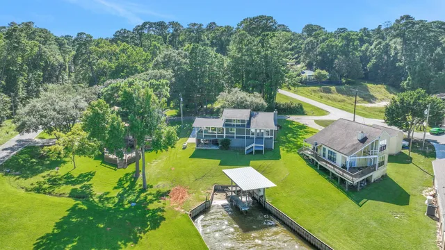 an aerial view of a house with swimming pool garden and trees