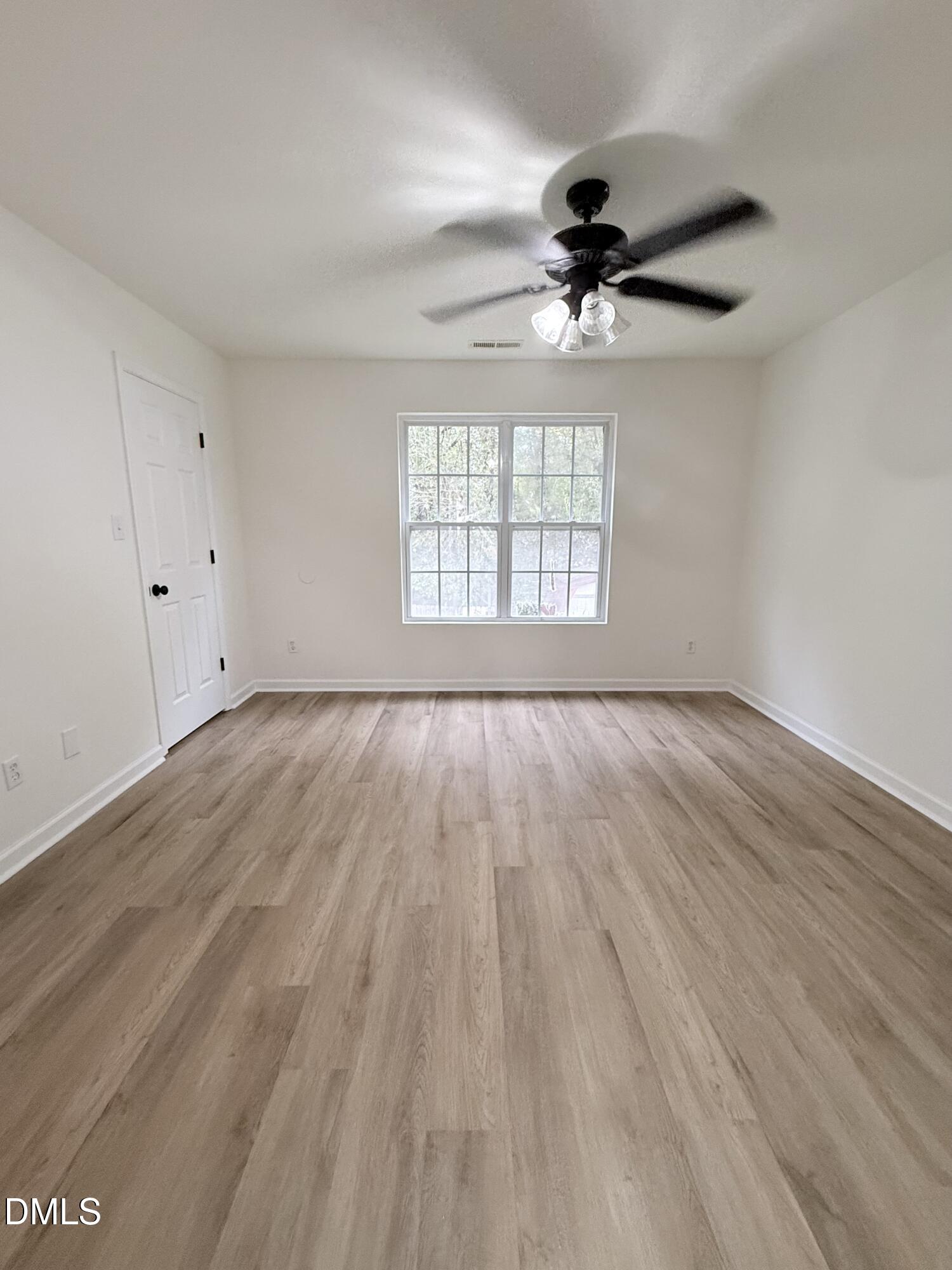4316 Haverty Drive Raleigh, NC 27610 - Photo 12 of 16 wooden floor in an empty room with a window