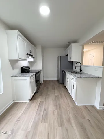a kitchen with granite countertop a sink cabinets and stainless steel appliances