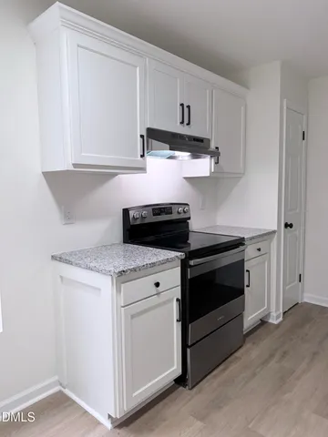a stove top oven sitting inside of a kitchen