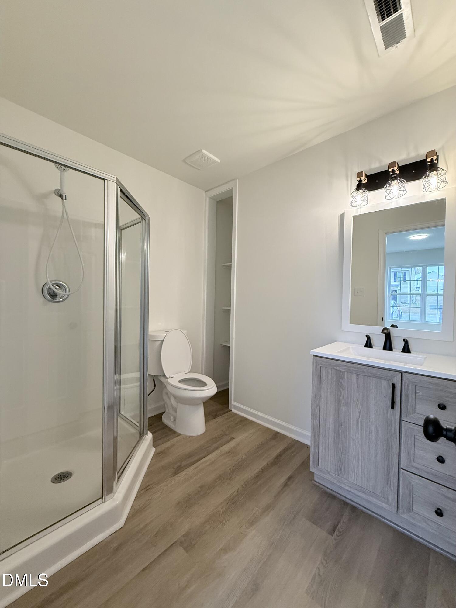 4316 Haverty Drive Raleigh, NC 27610 - Photo 9 of 16 a bathroom with a shower sink and mirror