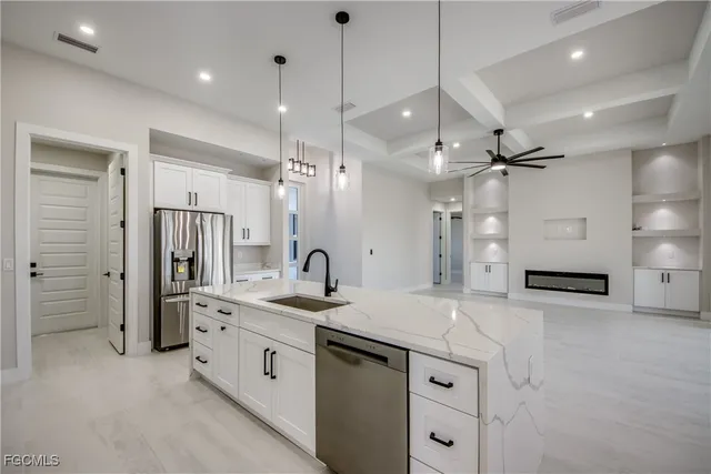 a kitchen with a sink stove a refrigerator and white cabinets