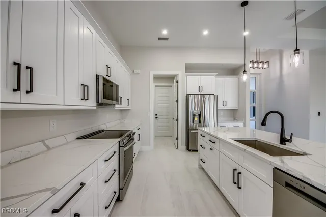 a kitchen with stainless steel appliances a sink stove top oven and refrigerator