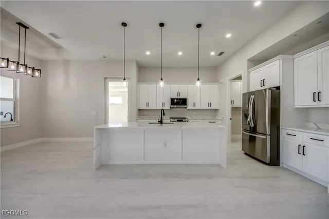 a large white kitchen with refrigerator stove and white cabinets