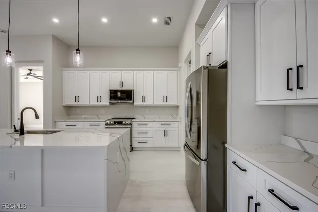a kitchen with stainless steel appliances granite countertop a refrigerator sink and microwave
