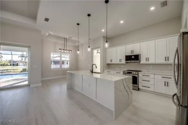 a large kitchen with white cabinets and wooden floor