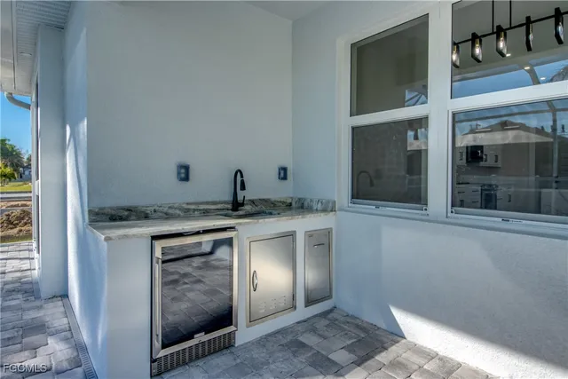 a view of kitchen with granite countertop cabinets and refrigerator