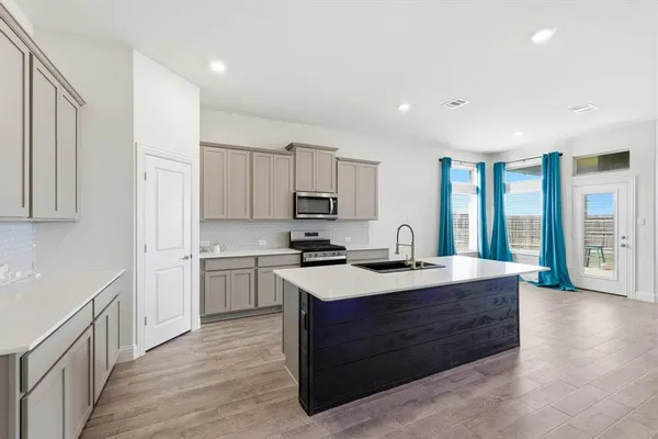 a kitchen with a stove top oven sink and cabinets