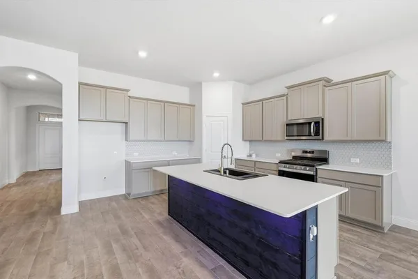 a kitchen with a sink stove top oven and refrigerator