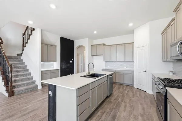 a kitchen with a sink stove and cabinets