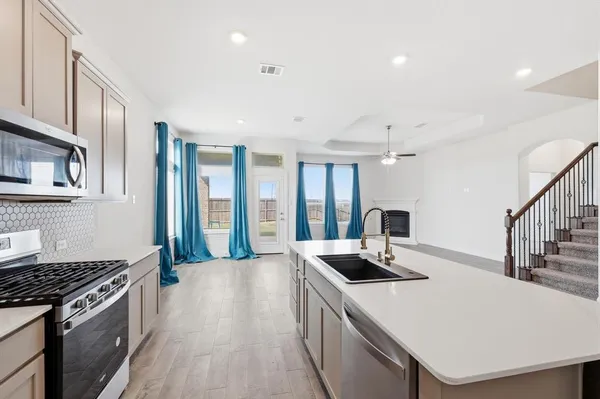 a kitchen with sink a stove and a refrigerator