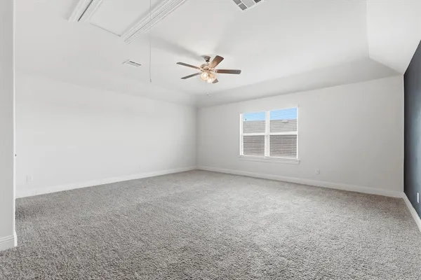 an empty room with windows and ceiling fan