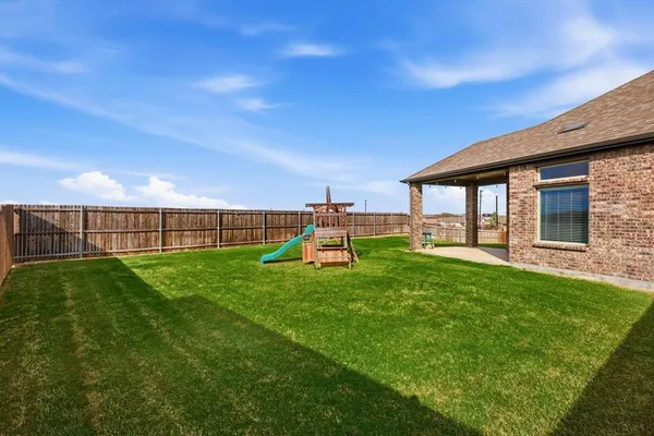 a view of a backyard with table and chairs a barbeque and wooden fence