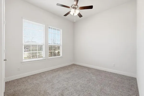 an empty room with a window and a fan