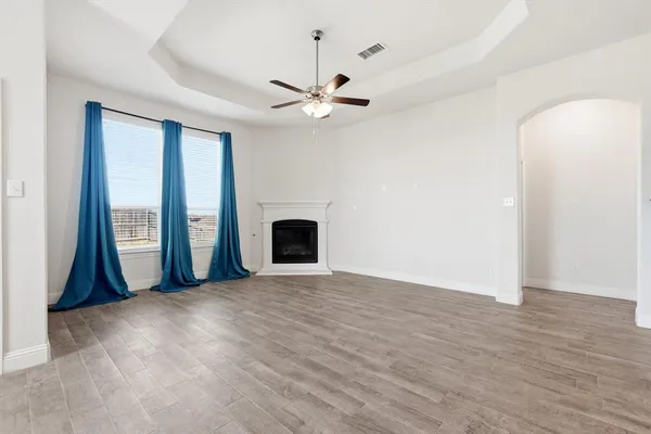 an empty room with windows and fireplace