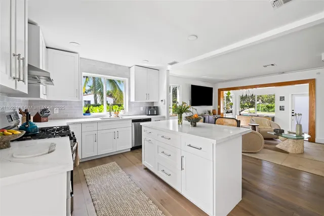 a kitchen with white cabinets and stainless steel appliances