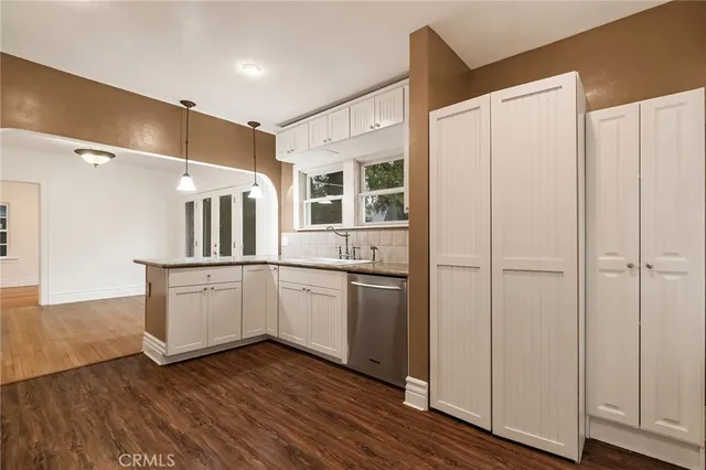 a kitchen with a refrigerator and white cabinets