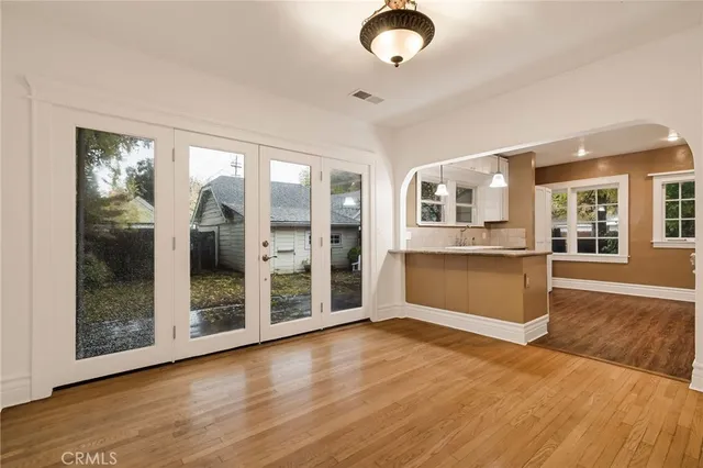 a view of an empty room with window and wooden floor