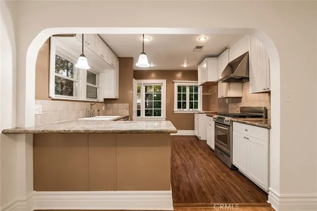a large kitchen with stainless steel appliances granite countertop a stove and a sink