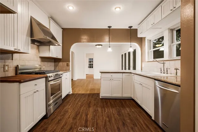 a kitchen with cabinets and wooden floor