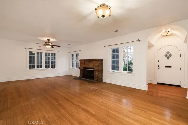 a view of an empty room with a window and fireplace