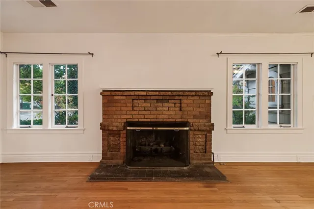 a living room with a fireplace and windows