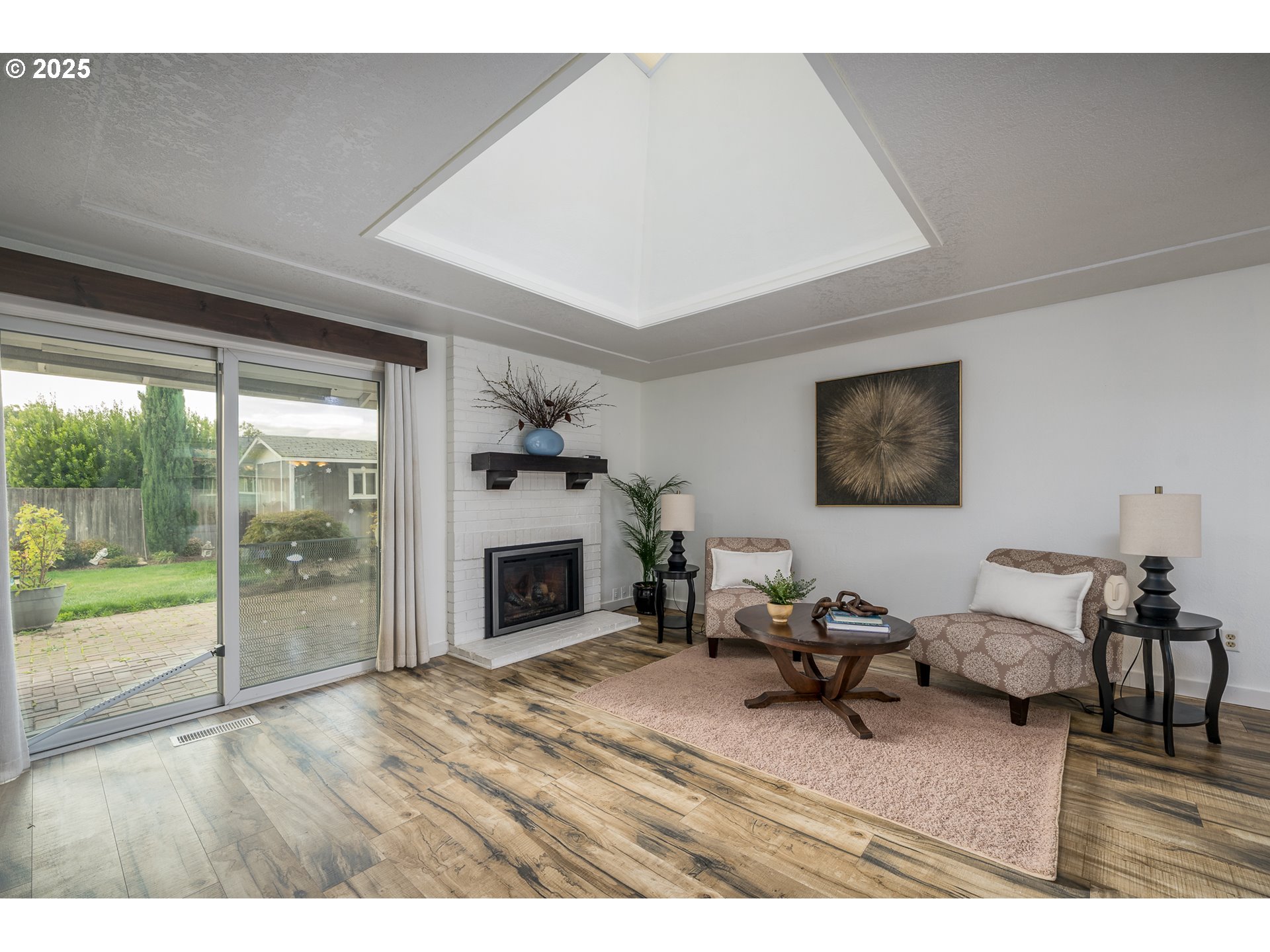 2676 Wheeler Street Southeast Albany, OR 97322 - Photo 5 of 32 a living room with furniture a fireplace and a floor to ceiling window