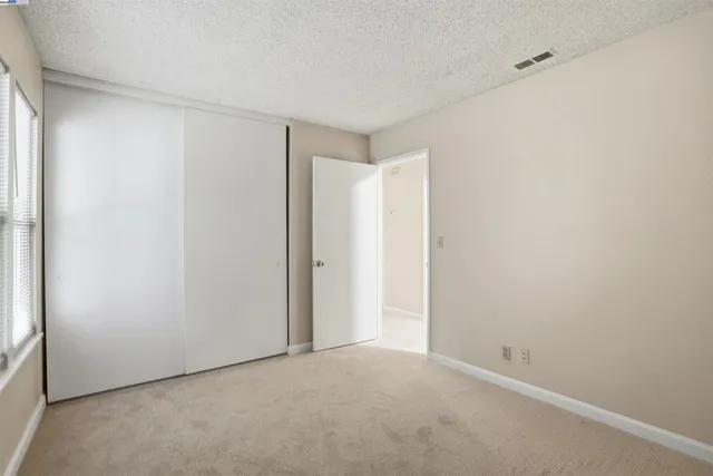 an empty room with closet and windows