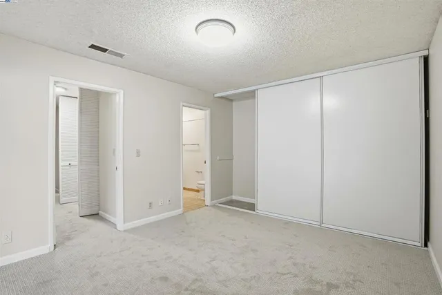 a bathroom with a granite countertop sink toilet and mirror