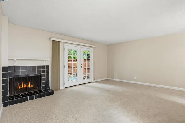 a view of an empty room with a fireplace and a fireplace