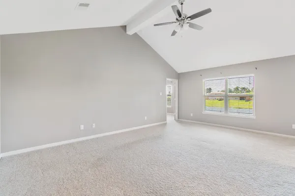 an empty room with a window and wooden floor