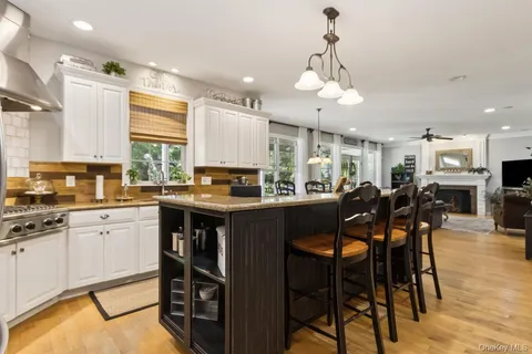 a kitchen with stainless steel appliances granite countertop table chairs sink and cabinets