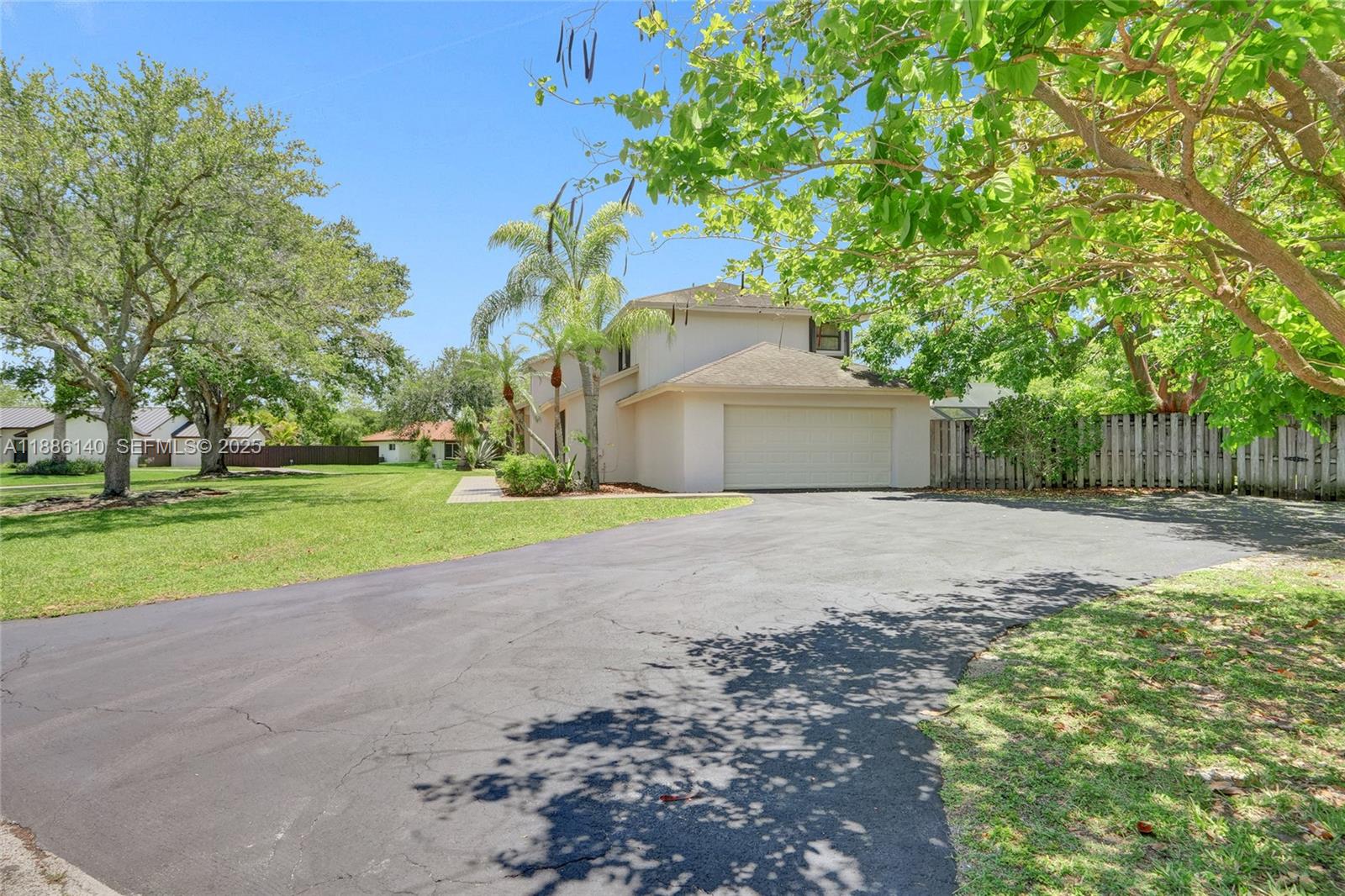 14940 Southwest 164th Terrace Miami, FL 33187 - Photo 11 of 73 a front view of a house with a yard and garage