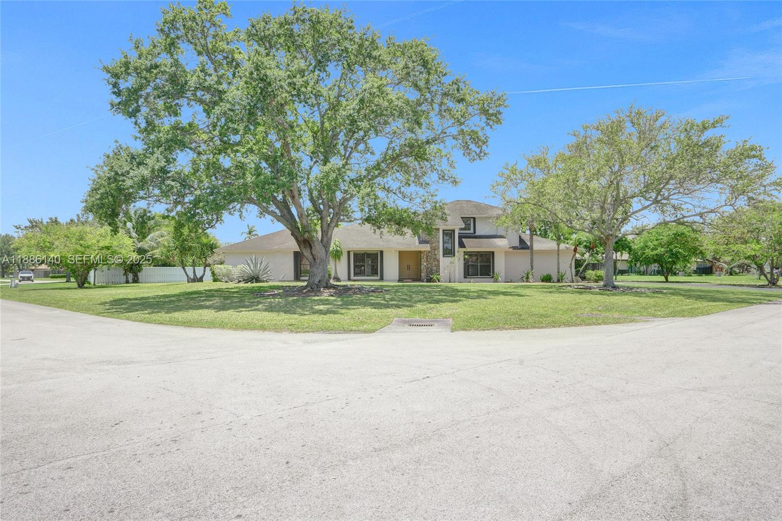 14940 Southwest 164th Terrace Miami, FL 33187 - Photo 14 of 73 a view of white house with a big yard and large trees