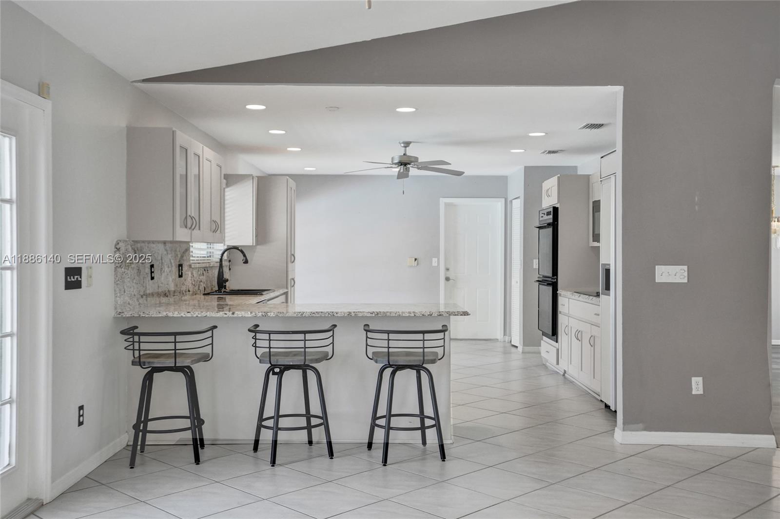 14940 Southwest 164th Terrace Miami, FL 33187 - Photo 26 of 73 a kitchen with stainless steel appliances kitchen island granite countertop a table and chairs in it