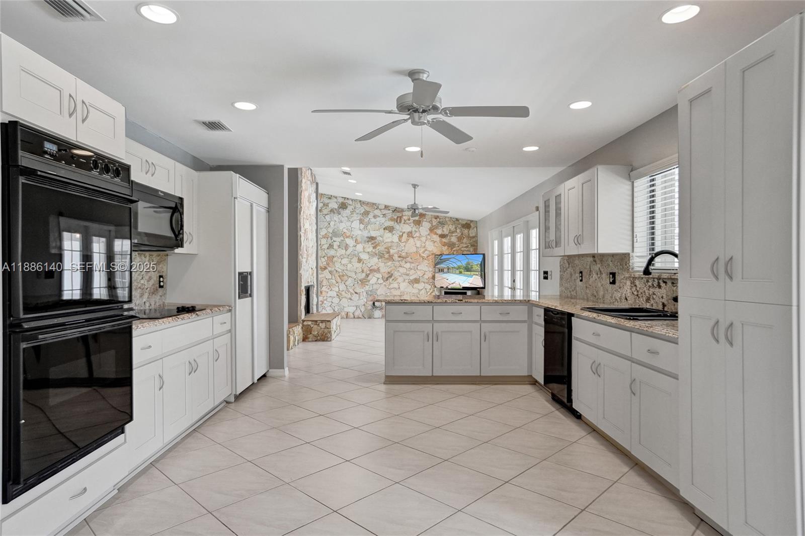 14940 Southwest 164th Terrace Miami, FL 33187 - Photo 31 of 73 a large white kitchen with a stove a sink dishwasher and a refrigerator