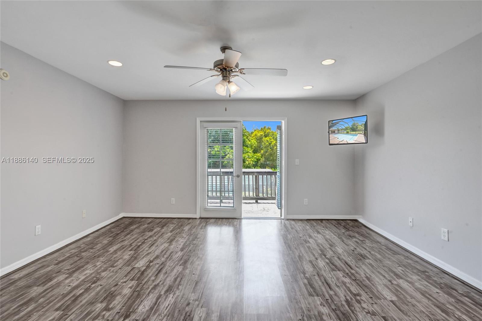 14940 Southwest 164th Terrace Miami, FL 33187 - Photo 35 of 73 a view of an empty room with wooden floor and a window