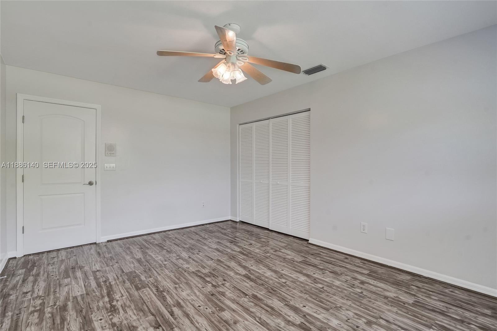 14940 Southwest 164th Terrace Miami, FL 33187 - Photo 47 of 73 a view of a room with wooden floor and a ceiling fan