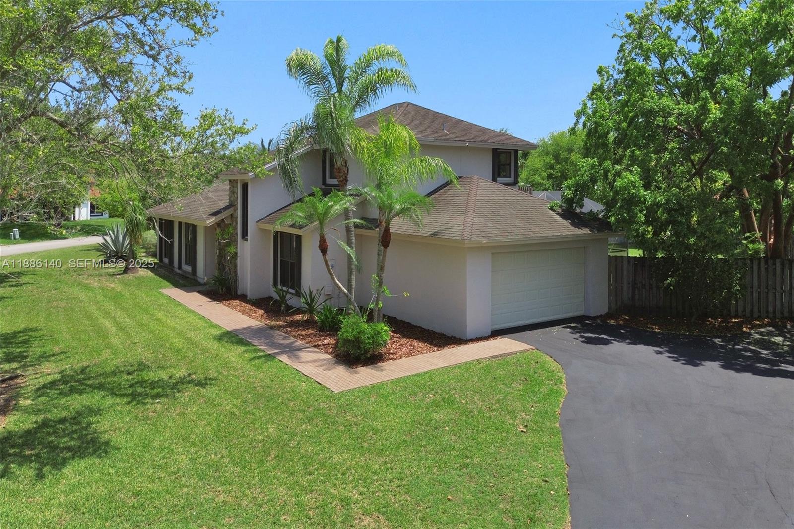 14940 Southwest 164th Terrace Miami, FL 33187 - Photo 5 of 73 a front view of a house with a yard and garage