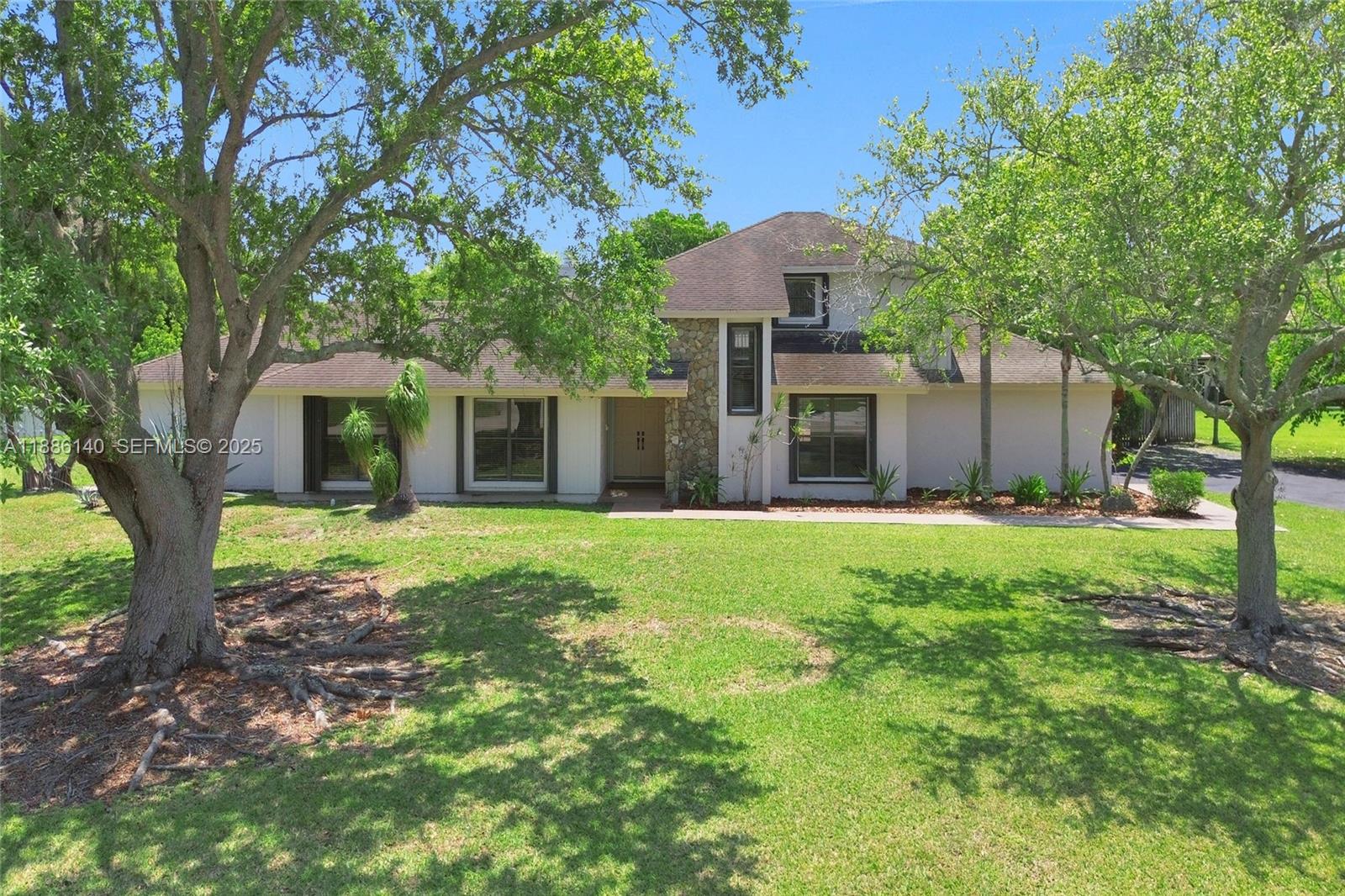14940 Southwest 164th Terrace Miami, FL 33187 - Photo 6 of 73 a view of a house with backyard and a tree