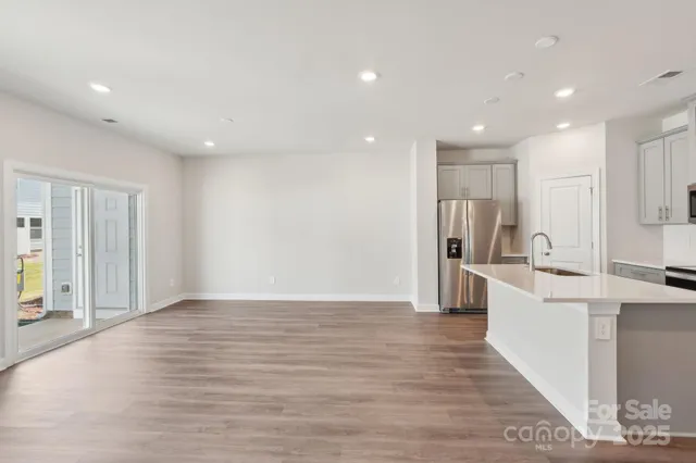 a view of kitchen with stainless steel appliances refrigerator oven and cabinets