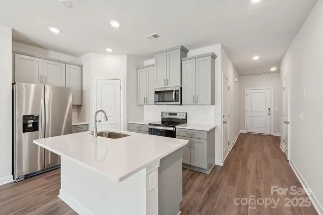 a kitchen with stainless steel appliances a refrigerator sink and microwave