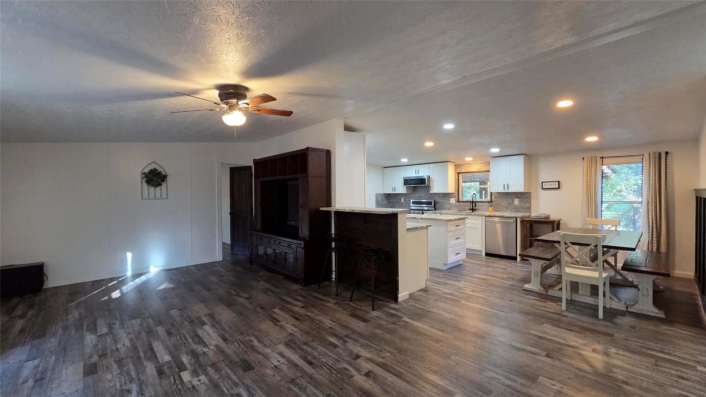 21150 Arnsworth Road Montgomery, TX 77356 - Photo 4 of 16 a open kitchen with cabinets a sink dishwasher a dining table and chairs with wooden floor